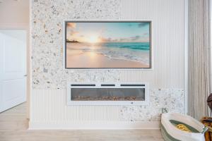 オレンジビーチにあるPhoenix X 102 condoの海の絵が飾られた暖炉のあるリビングルーム