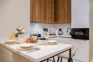 a kitchen with a table with plates and wine glasses at Luxe Apartment 18-th floor and sky view in Tashkent City NRG U-Tower in Tashkent