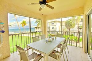 a dining room with a table and chairs and the ocean at Plantation Village #20 Condo in Seven Mile Beach +69 photos