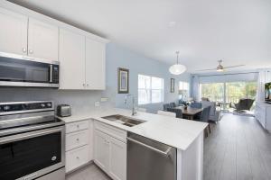 a kitchen with white cabinets and a dining room at Plantation Village #37 Condo in Seven Mile Beach +82 photos