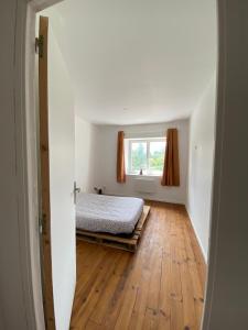 a bedroom with a bed and a window at Petite maison de bourg in Le Bourgneuf-la-Forêt