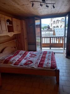 ein Schlafzimmer mit einem Bett und einem großen Fenster in der Unterkunft appartement les belettes chaleureux et cosy in Peisey-Nancroix
