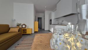 a living room with a couch and a glass vase at La casa delle margherite - Tirano in Tirano