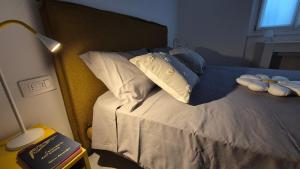 a bed with blue and white pillows and a lamp at La casa delle margherite - Tirano in Tirano