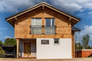 una casa con un balcón encima en Chalet SiSa, en Ižipovce
