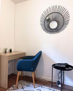 Habitación con silla azul y espejo. en Apartment 10 mins from Paris, en Rosny-sous-Bois