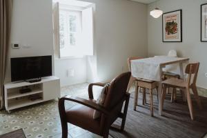 a living room with a dining room table and a television at S. Pedro 27 in Sintra