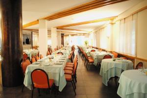 a dining room with tables and chairs with white tablecloths at Hotel Meranda in Camigliatello Silano