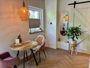 a room with a table and chairs and a mirror at Bij Julia in Den Burg