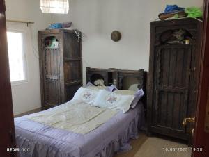 a bedroom with a bed and two wooden cabinets at Authentic Guesthouse with Garden and Mountain View Beni Mellal in Beni Mellal