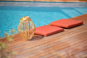 a vase and two cushions next to a swimming pool at Hôtel Le Ribéral in Cerbère