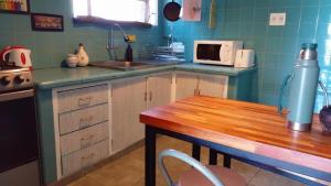 a kitchen with a sink and a table with a microwave at Apartamento Céntrico con Balcón in Paysandú