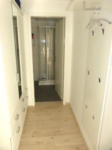 a hallway leading into a bathroom with a walk in shower at Leuchtturm in Juist +10 photos