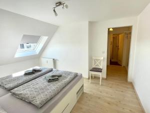 a white bedroom with a bed and a window at Leuchtturm in Juist