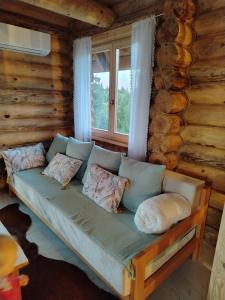 a couch in the living room of a log cabin at Beloglavi sup in Nova Varoš