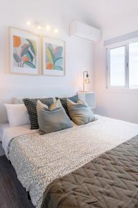 ein großes Bett in einem weißen Zimmer mit zwei Fenstern in der Unterkunft Casa Checha Romántico Ático con vistas increíbles in Candelaria