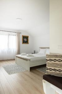 a white bedroom with a bed and a window at Seren Natura Retreat in Sebeşu de Sus