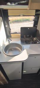 a kitchen with a sink and a stove in an rv at Autocaravana El quijote in Albacete +1 photo