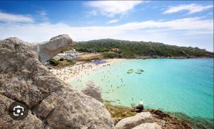 a group of people in the water at a beach at MONO SUITE - Rena Bianca in Santa Teresa Gallura