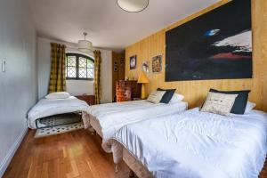 a bedroom with two beds and a painting on the wall at Maison avec piscine, proche Chenonceau et Amboise in La Croix-en-Touraine +29 photos