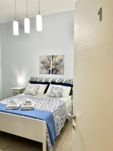 a bedroom with a bed with a blue and white bedspread at a casa rà Palumma Rooms in Avola
