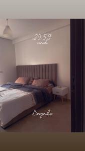 a bedroom with a bed and a side table at Appartement vu sur piscine à 5 minutes de la plage in Mansouria +2 photos