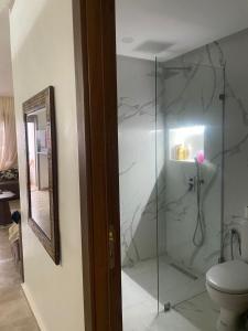 a bathroom with a glass shower with a toilet at Appartement vu sur piscine à 5 minutes de la plage in Mansouria
