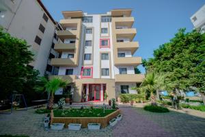 a building with a garden in front of it at Kadrisa Hotel in Durrës