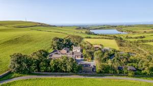 an aerial view of a house in a field with a lake at Ash Lodge in Ulverston