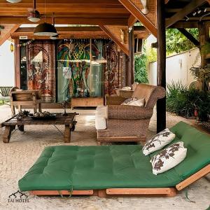 a green couch on a patio with a table at Taj Hotel in Três Lagoas
