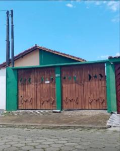 ein Gebäude mit zwei Toren mit Graffiti darauf in der Unterkunft Casa in Mongaguá