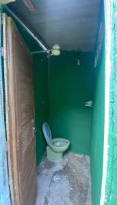 ein grünes Bad mit einem WC in einer grünen Wand in der Unterkunft Casa in Mongaguá