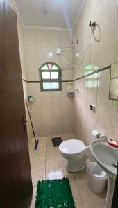 ein Badezimmer mit Toilette und Waschbecken in der Unterkunft Casa in Mongaguá