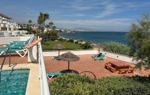 basen z leżakami i parasolami oraz ocean w obiekcie Sinfonia Del Mar Apartment also LONG TERM RENTALS w mieście Estepona