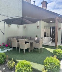 Un patio con una mesa y sillas y una sombrilla. en Eduard Inn, en Vulcan