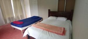 une chambre avec deux lits avec des draps bleus et rouges dans l'établissement Hospedaje Herradura de Rivas, à Rivas