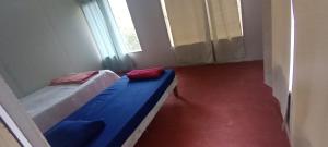 une chambre avec deux lits et une fenêtre dans l'établissement Hospedaje Herradura de Rivas, à Rivas 3 autres photos