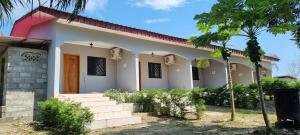 una pequeña casa blanca con techo rojo en Les cocons du cap santa-clara à Libreville-Gabon, en Lope