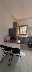 una cocina con una mesa y una silla. en Les cocons du cap santa-clara à Libreville-Gabon, en Lope