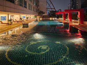 een zwembad met een nummer in het water 's nachts bij Kuma House Asoke in Bang Kapi +10 foto's