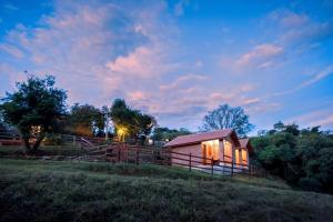 a small cabin in a field with a fence at Chalés Pedacim du Céu in Bueno Brandão