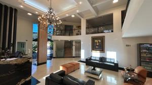 Una sala de estar con sofás y una lámpara de araña. en Havana Palace Hotel, en Uberaba