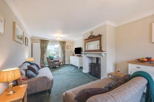 a living room with two couches and a fireplace at Pound Cottage in Holt