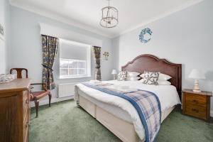 a bedroom with a bed and a desk and a window at Pound Cottage in Holt