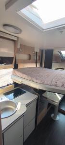 een kleine kamer met een stapelbed en een wastafel bij Autocaravana El quijote in Albacete