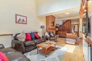 a living room with a leather couch and a table at Fieldview in East Barsham