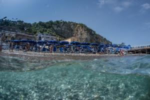 a view of a beach with umbrellas and the water at Hotel Baia Di Puolo in Massa Lubrense