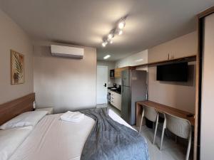 a room with a bed and a desk and a kitchen at MUV403 - Modern Studio in the Center in Curitiba