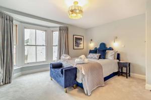 ein Schlafzimmer mit einem blauen Bett und einem blauen Stuhl in der Unterkunft Cornfield Terrace in Southwold