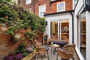 eine kleine Terrasse mit Stühlen und einem Tisch in der Unterkunft Cornfield Terrace in Southwold